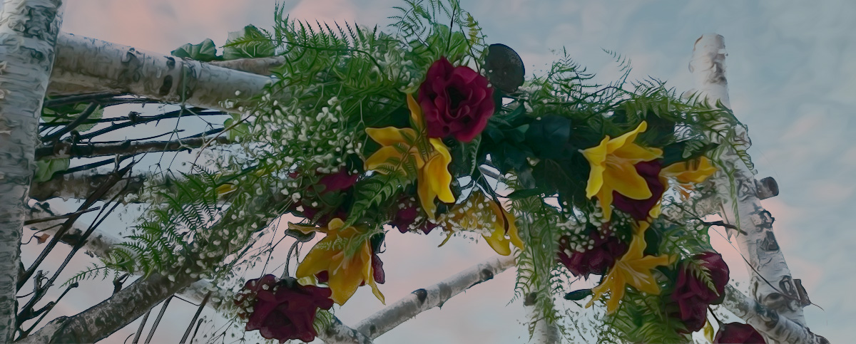 birch wedding arbor with red and yellow flowers